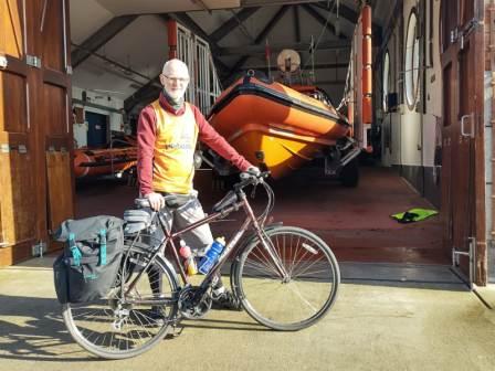 Phil Morcom with his bicycle outside an RNLI lifeboat station.
