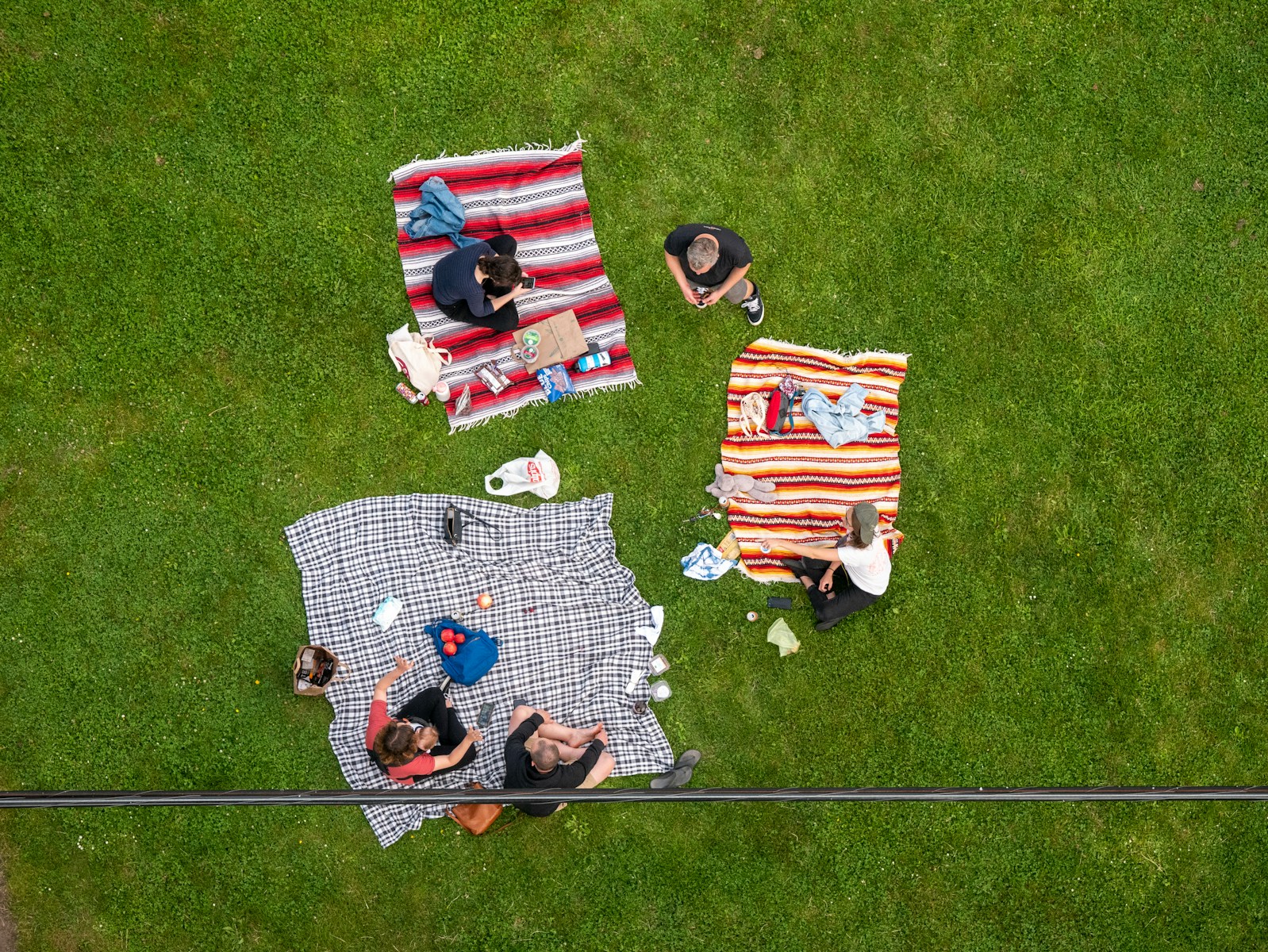 red white and black blankets on green grass field