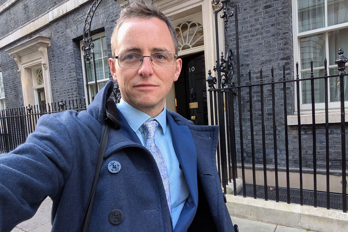 Selfie taken by man in suit outside 10 Downing Street.