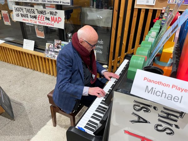 A man playing the piano with Michael written on a sign