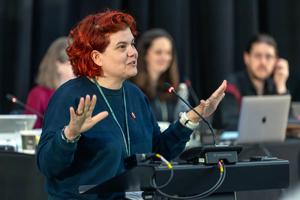 A woman speaks at a lecturn.