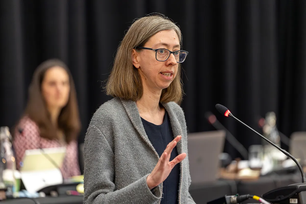 Woman giving a speech at a lecturn.