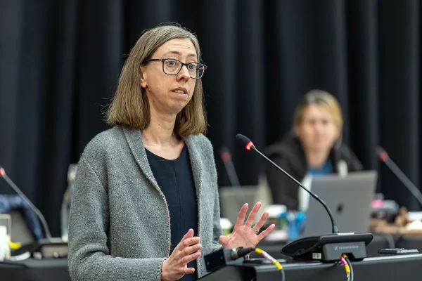 Woman giving a speech at a lecturn.